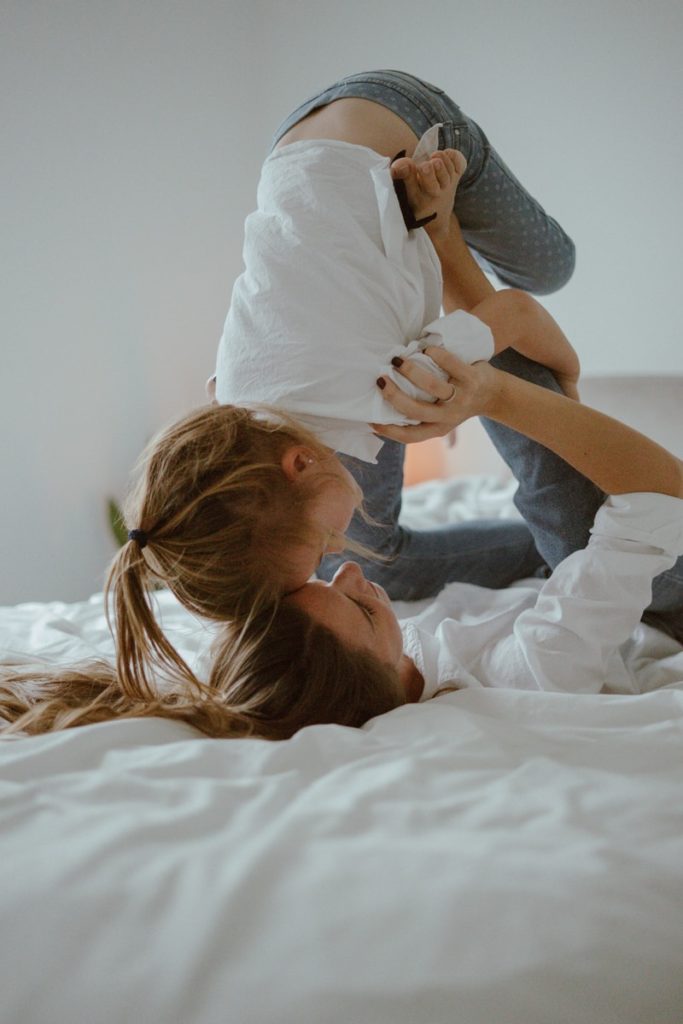 woman in white shirt lying on bed