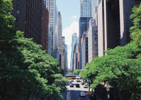 yellow car running on the street between the building during daytime