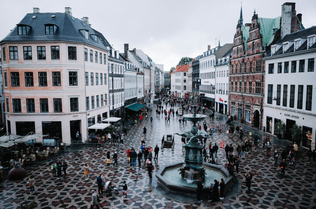 Pedestrians shopping along Strøget street, enjoying Copenhagen's retail scene after moving to the city.